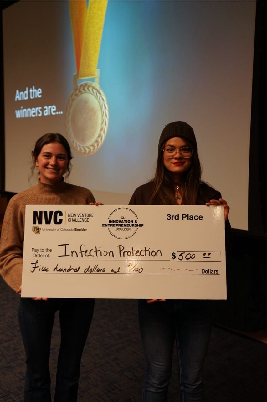 Two students holding a winner's bounty check